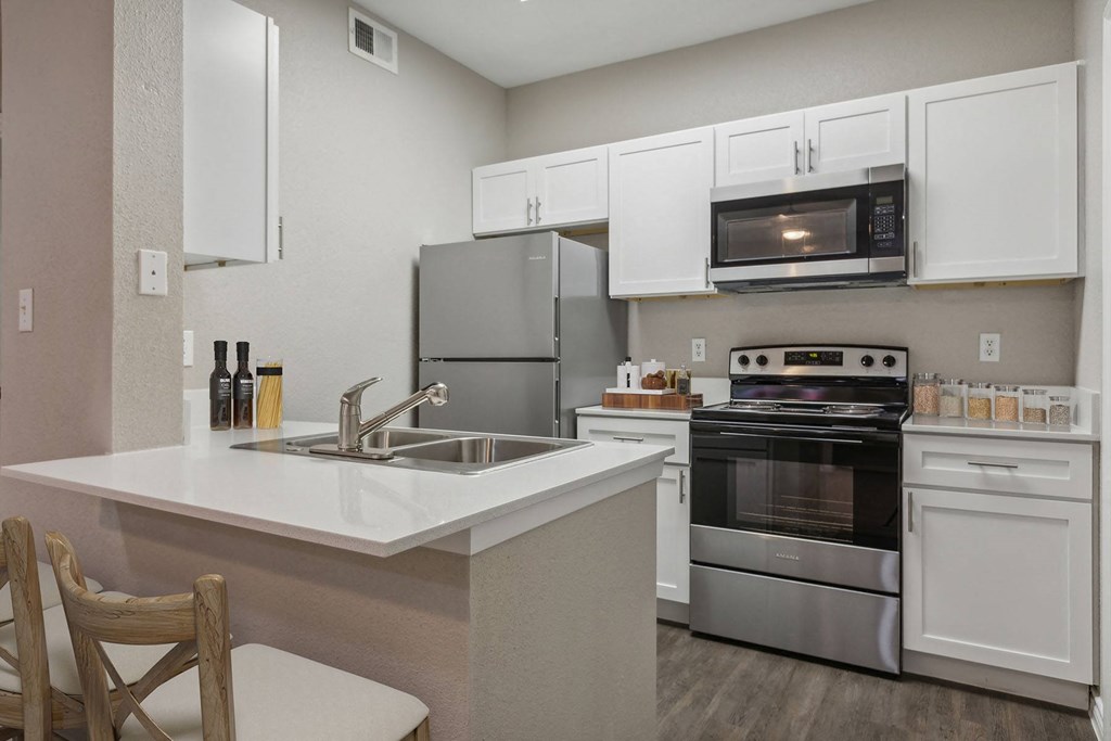 Kitchen with stainless steel appliances a kitchen with stainless steel appliances and white cabinets